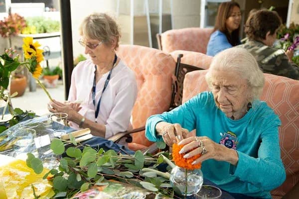 Residents arrange flowers outdoors