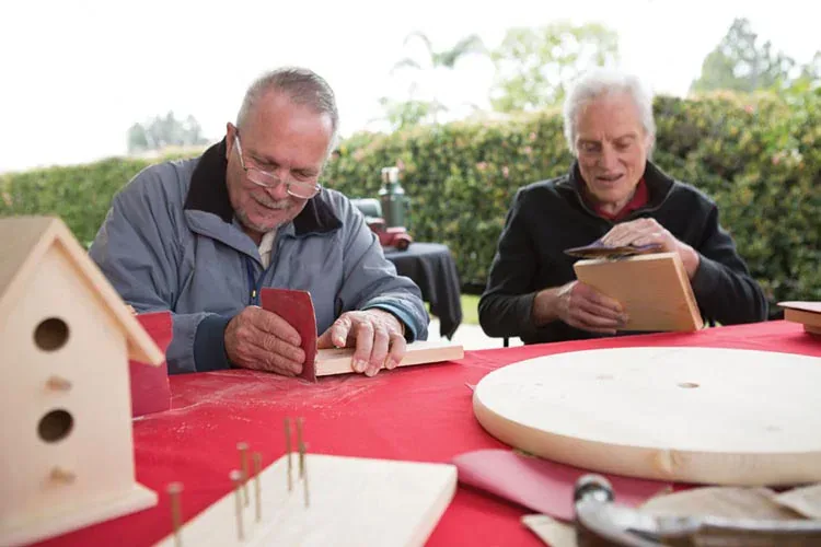Residents build birdhouses outdoors