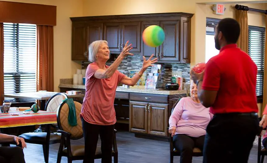 A resident catches a ball during an exercise activity