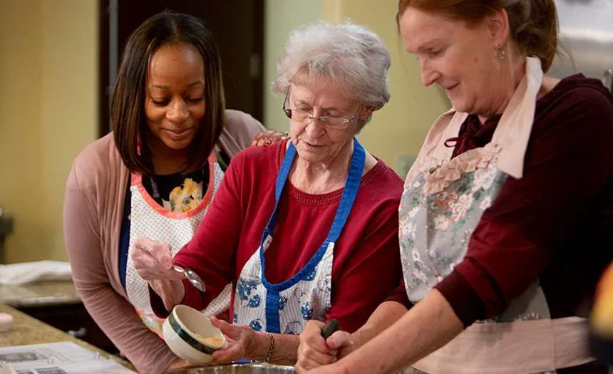 Residents and a team member bake together