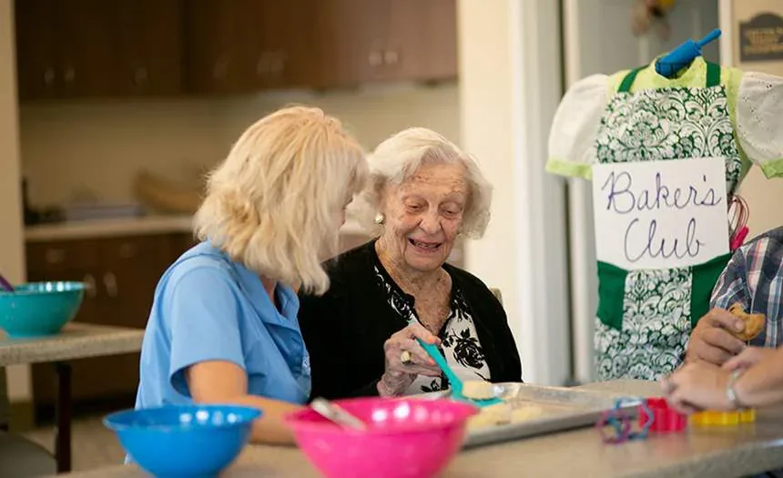 A resident and team member bake together